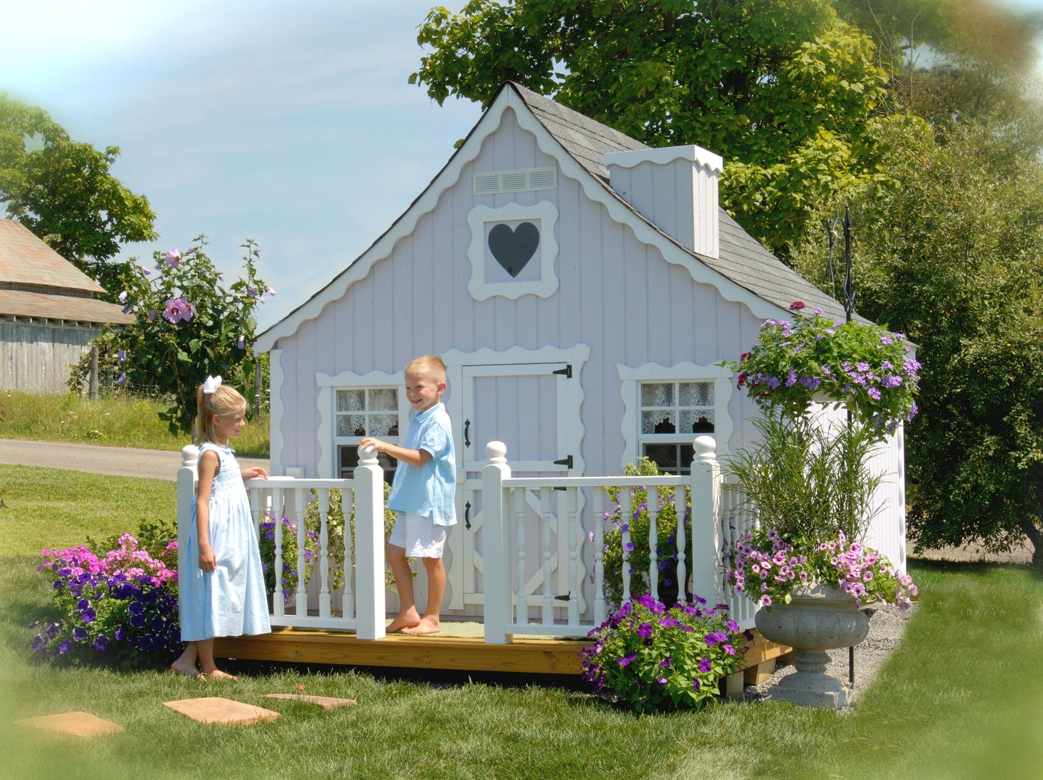 8x10 Gingerbread Cottage Playhouse with deck and rail. Kids are playing outside