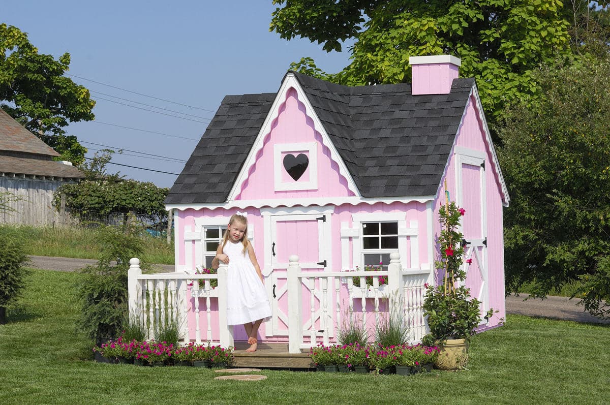 8x8 Victorian Playhouse with deck and rail and kid in front