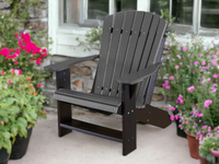 Wildridge adirondack chair in dark gray and black on a patio with flowers